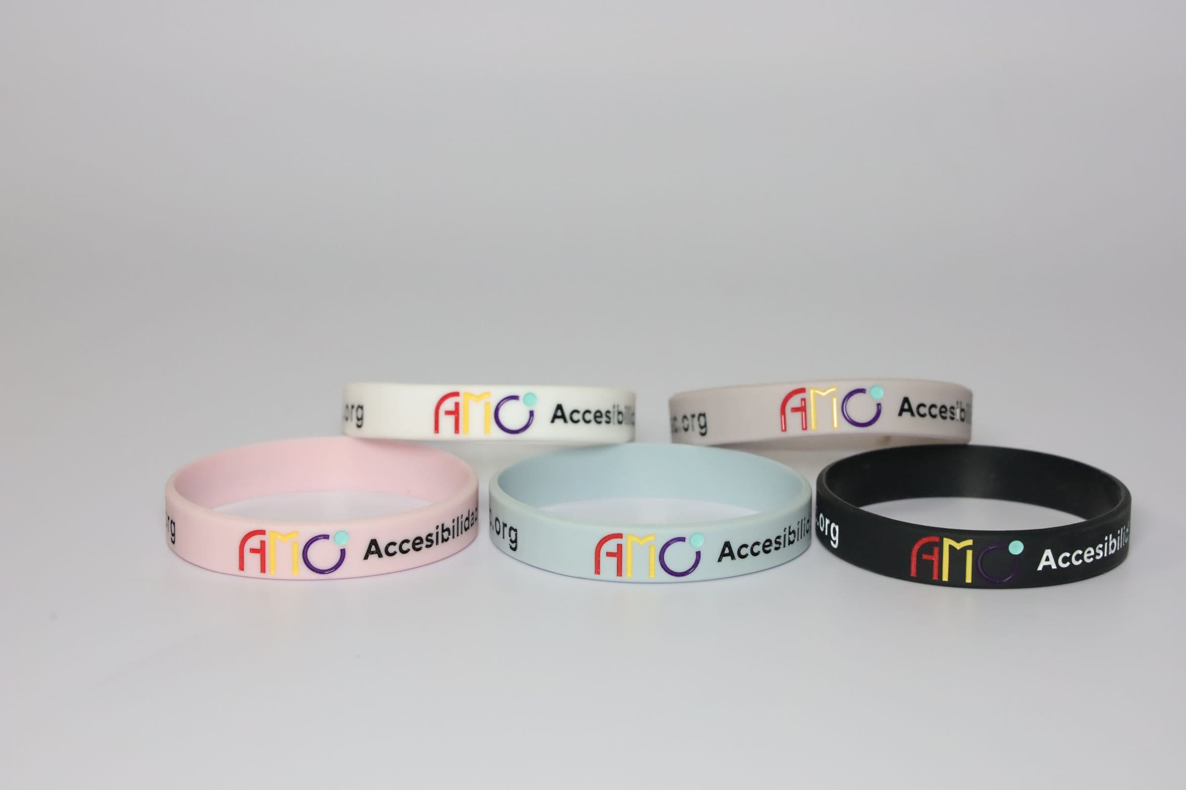 Las cinco pulseras de AMO en fila sobre fondo gris