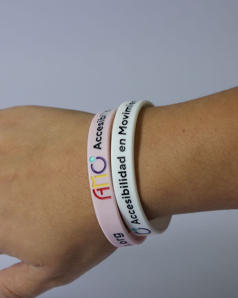 Muñeca con tres pulseras de AMO: rosa, blanca y lila